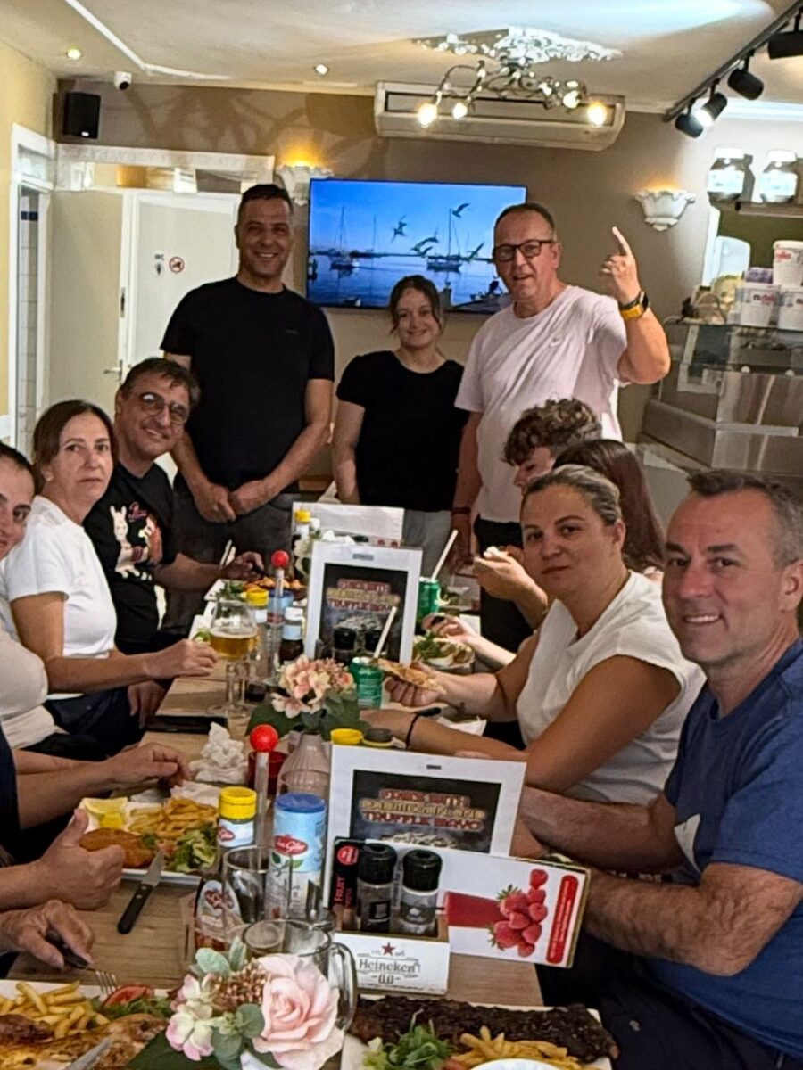 De hele groep aan de lange tafel met ons team erachter