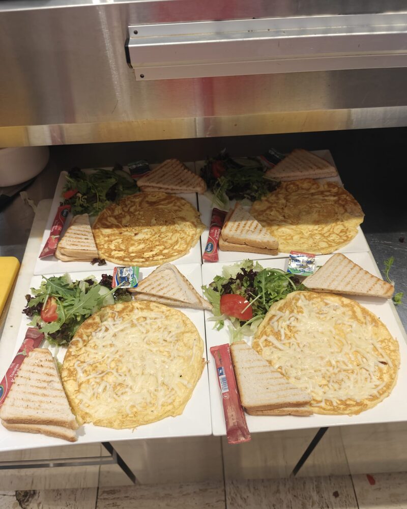 Vier kaasomeletten met getoast brood en salade, klaar op de werkbank
