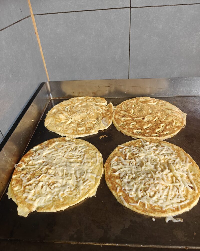 Vier Hollandse pannenkoeken naast elkaar op de hete bakplaat