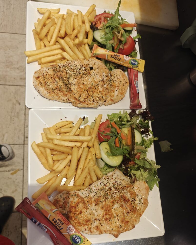 Twee borden kipschnitzel met friet en gemengde salade