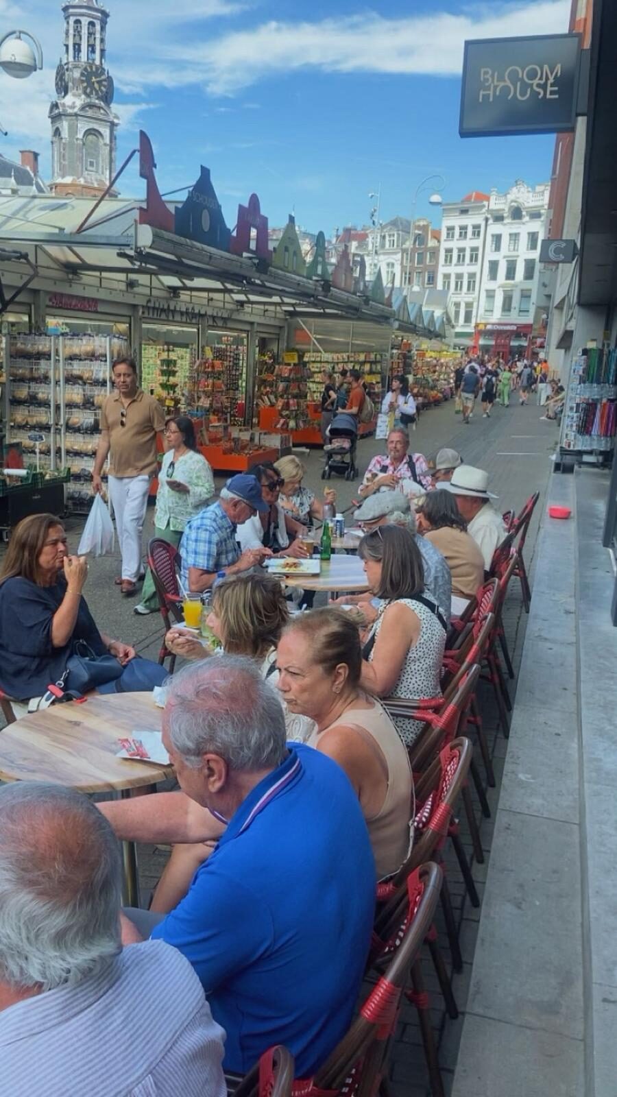 Gasten aan terrastafels langs de Singel op een zonnige middag