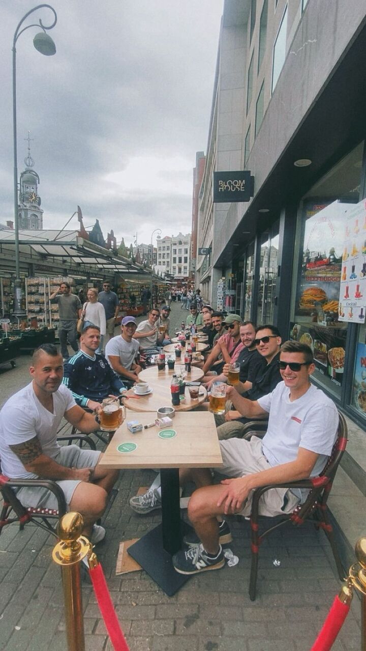 Een grote groep vrienden proost op het terras van Amarylles bij de bloemenmarkt
