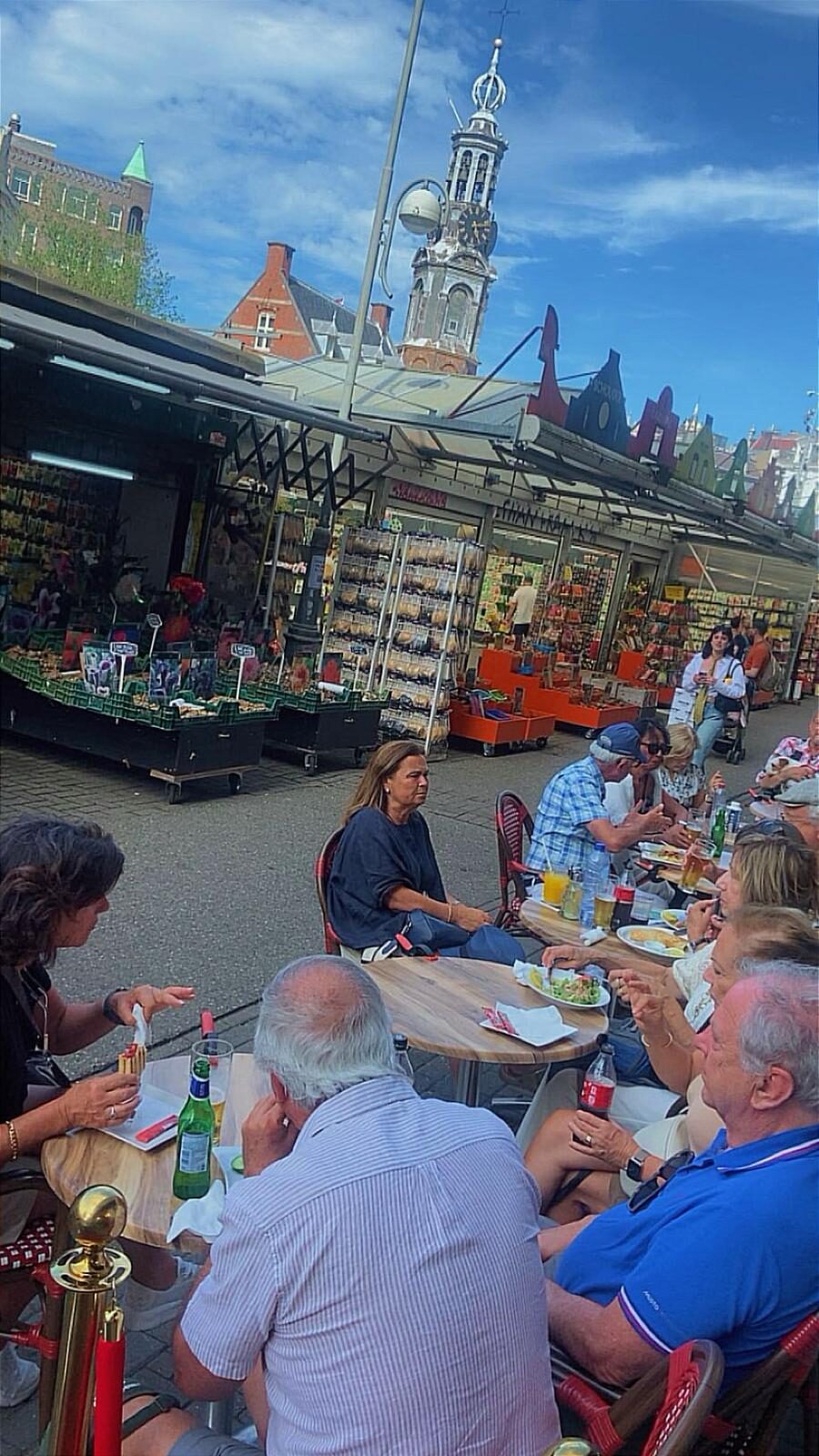 Het terras aan de Singel met de kramen van de bloemenmarkt en de Munttoren erachter